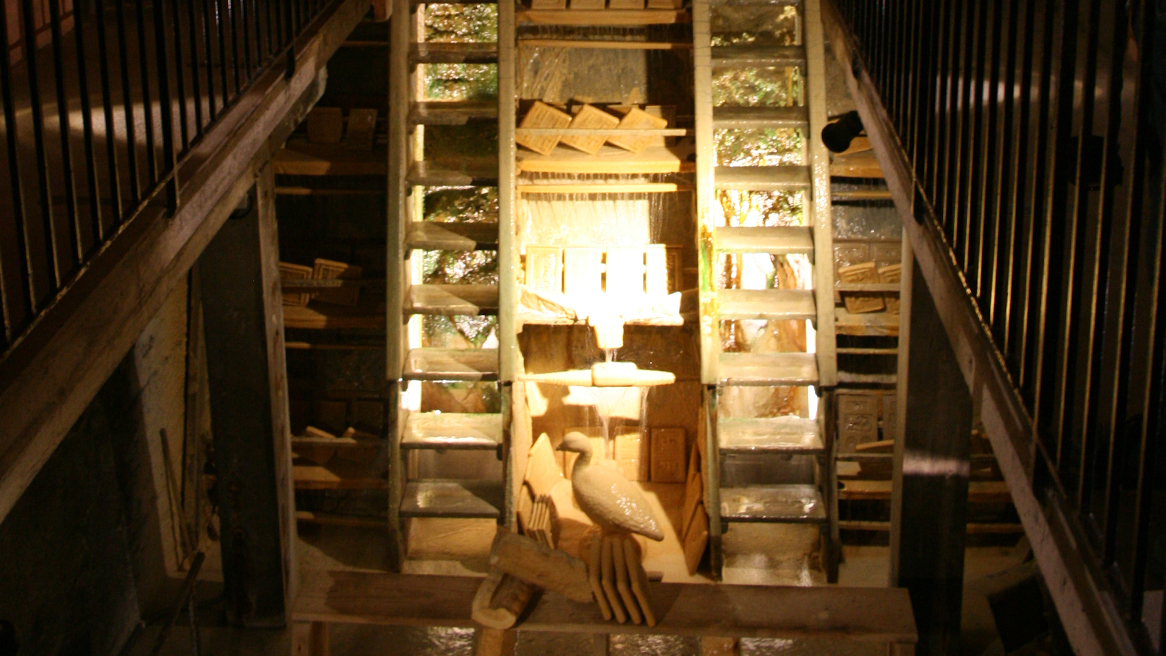 Two viewing platforms provide a view of a very large ladder which is stacked with moulds and onto which water is constantly dripping